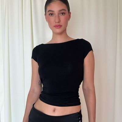 Heiße, schlanke, sexy, rückenschaltene, kurze, straßene, kurzärmelige T-Shirt-Frau.